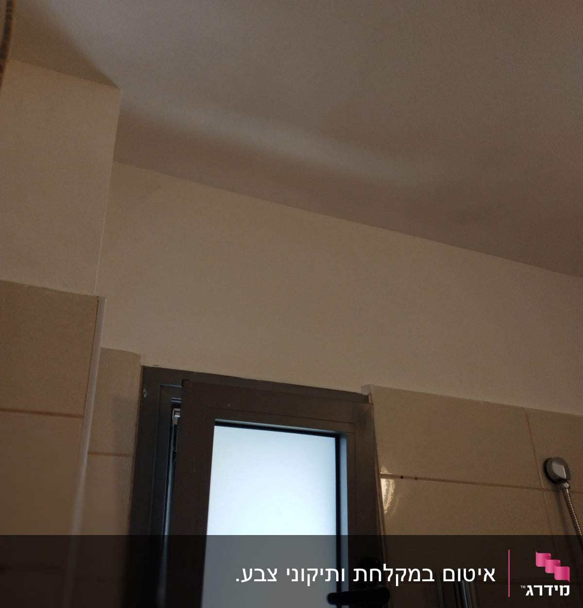 קיר צבוע בלבן ליד חלון עם מסגרת מתכת